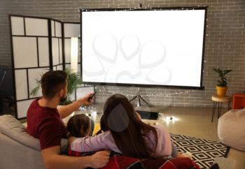 Young family watching movie at home�