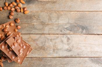 Sweet chocolate with nuts on wooden table�