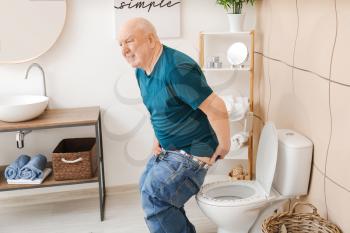 Elderly man with hemorrhoids visiting restroom�