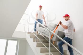 Loaders carrying furniture in the stairway�