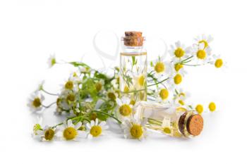 Bottles with chamomile essential oil on white background�