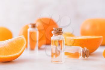 Bottles with orange fruit essential oil on table�