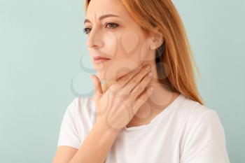 Woman with thyroid gland problem on light background�