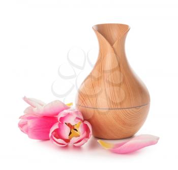 Aroma oil diffuser and flowers on white background�