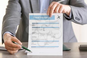 Male agent with travel insurance form, closeup�