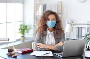 Female lawyer in protective mask working in office�