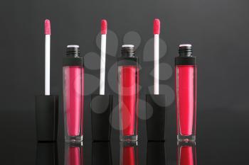 Different liquid lipsticks on grey background�