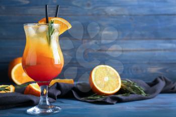 Fresh summer cocktail in glass on color wooden table�