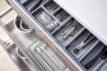 Set of clean kitchen utensils in drawer�