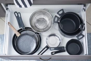 Set of clean kitchenware in drawer�