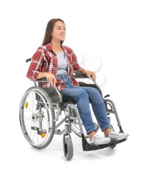 Young woman sitting in wheelchair on white background�