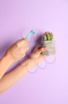 Woman holding razor and cactus on color background�