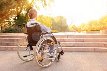 Girl in wheelchair near stairs outdoors�