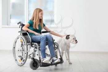 Teenage girl in wheelchair and her dog at home�