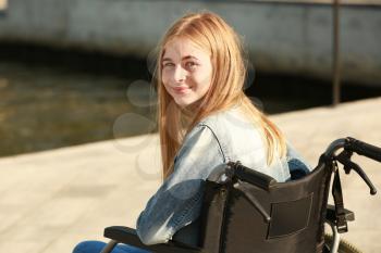 Teenage girl in wheelchair near river�
