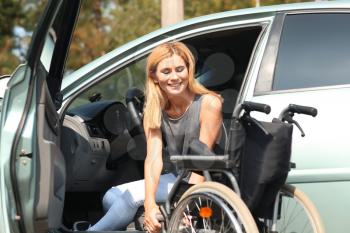 Handicapped woman getting out of her car�