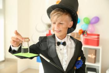 Cute little magician showing trick indoors�