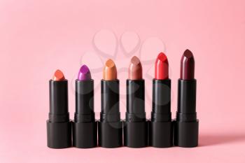 Lipsticks of different shades on color background�
