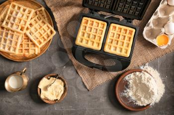 Modern waffle maker with ingredients on grey table�