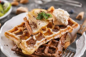 Delicious waffles with pear slices and ice cream on plate�