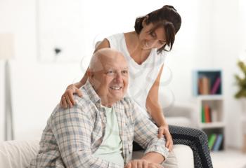 Happy elderly man with his daughter at home�