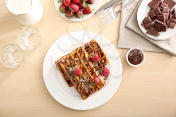 Plate with delicious waffles and berries on table, top view�