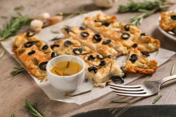 Traditional Italian Focaccia with rosemary, olives and oil on table�