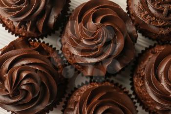 Tasty chocolate cupcakes on white wooden table, top view�