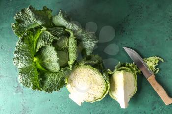 Whole and cut savoy cabbages on color table�