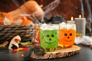 Creative glasses with jelly dessert prepared for Halloween party on dark table�