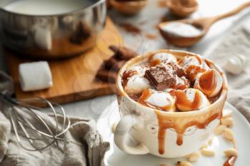 Cup of hot chocolate with marshmallows and caramel on table�
