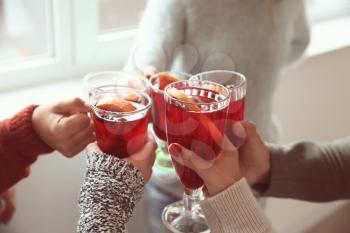 Friends drinking delicious mulled wine at party�