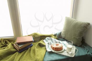 Cozy place for rest with books and tasty breakfast on windowsill�