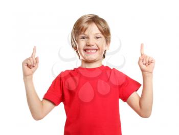 Little boy in t-shirt pointing at something on white background�