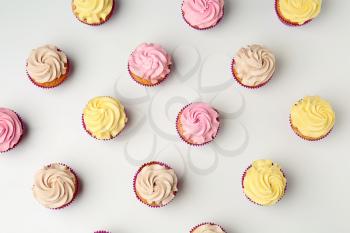 Delicious cupcakes on white background, flat lay�