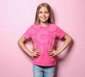 Smiling little girl in t-shirt on color background�