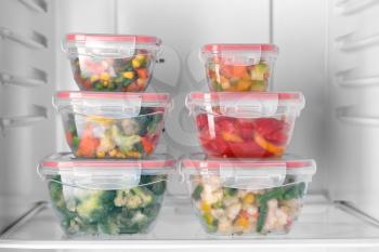 Containers with frozen vegetables in refrigerator�