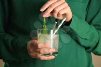 Woman holding glass of fresh aloe vera juice, closeup�