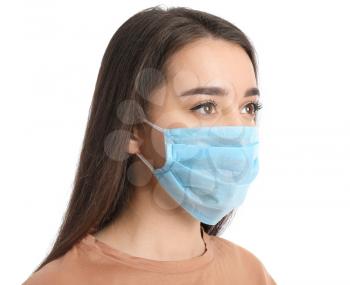 Young woman wearing medical mask against white background�