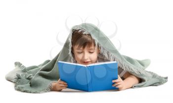 Little boy wrapped in plaid reading book on white background�