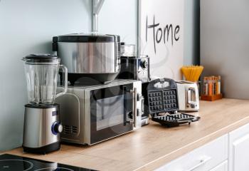 Different household appliances on table in kitchen�