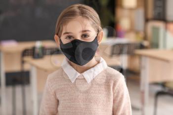 Little girl wearing medical mask at school�