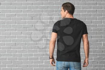Man in stylish t-shirt on brick background�
