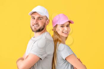 Young couple in stylish caps on color background�
