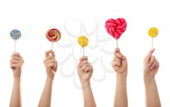 Hands with sweet lollipops on white background�