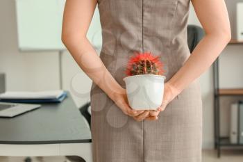 Young businesswoman with cactus in office. Hemorrhoids concept�