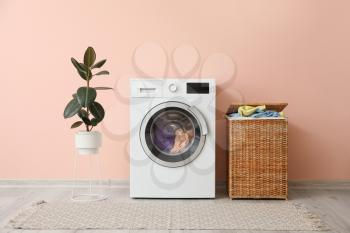 Washing machine and basket with laundry near color wall�