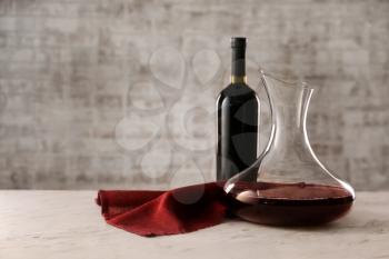 Decanter and bottle of wine on table�