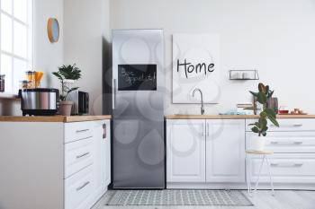 Stylish interior of modern kitchen with big refrigerator�