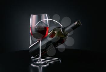 Holder with bottle and glass of wine on dark background�